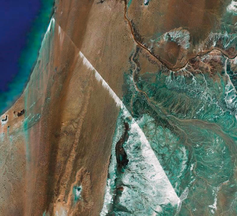 Zu sehen ist ein Satellitenbild des längsten Förderbandes der Welt. Es befindet sich in der Westsahara und transportiert Phosphat. Dies ist auch aus großer Höhe als weiße Streifen zu erkennen ist. Link zur vergrößerten Darstellung des Bildes.