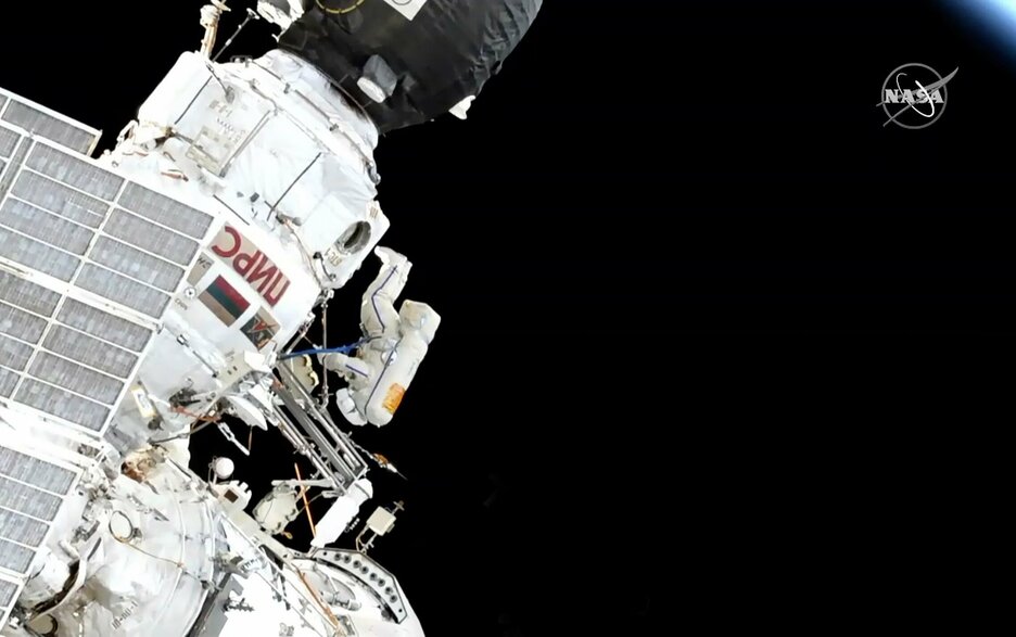 Das Bild zeigt die Raumstation ISS von außen im Weltall und einen Astronauten, der kopfüber schwebt und von außen Reinigungsarbeiten durchführt.  Link zum Artikel.