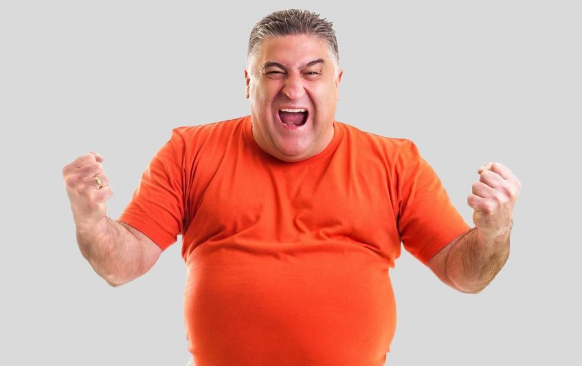 Zu sehen ist ein kräftiger Mann im orangefarbenem T-Shirt, der seine Fäuste ballt und kraftvoll schreit. Dies Symbolfoto für den Selbst-Check Zufriedenheit im Job soll die Kraft verdeutlichen, die entsteht, wenn alles super läuft im Job. Link zum Artikel.