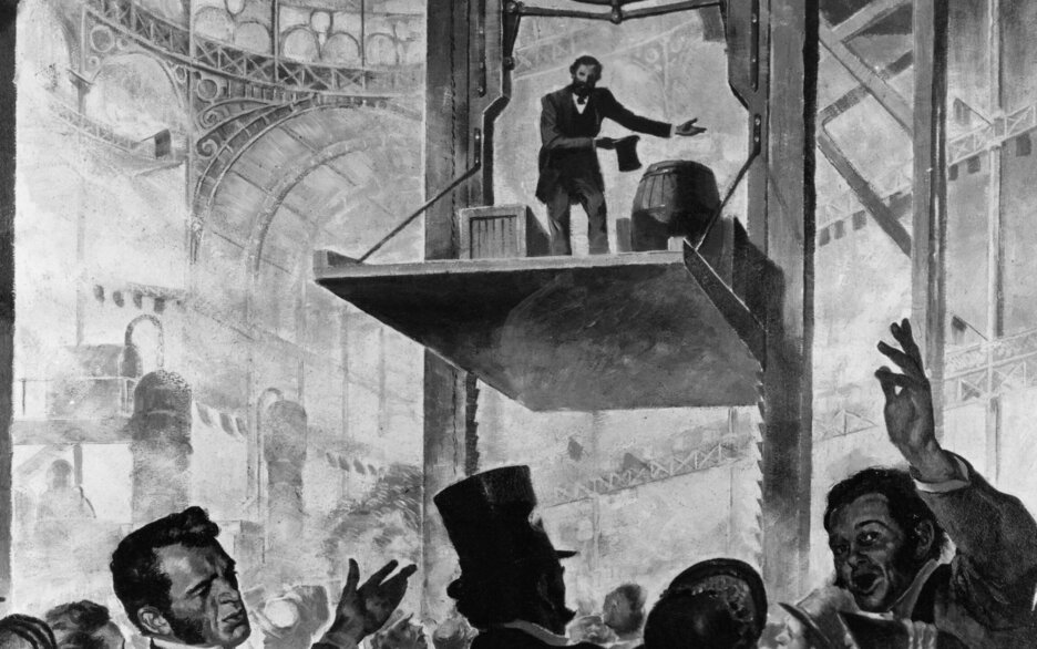 Das Schwarz-Weiß-Bild ist eine illustrative Darstellung der Weltausstellung 1854. Im Vordergrund auf der unteren Seite des Bildes ist eine Menschenmenge zu sehen, die sich aufgeregt und erstaunt miteinander unterhält. Über ihnen im Hintergrund ist ein großes Holzgestell zu sehen. Zwischen 2 vertikalen Schienen mit vielen Zähnen auf der Innenseite schwebt eine Plattform. Auf dieser stehen Kisten, Fässer und der Erfinder Elisha Graves Otis, der seinen Zylinder gezogen hat und sich verbeugt. Über ihm ist seine Erfindung zu sehen. Unter einem waagerechten Holzbalken befindet sich eine große Metallfeder, an deren Seiten links und rechts 2 Keile angebracht sind. Über dem Holzbalken ist ein durchgeschnittenes Seil. Link zum Artikel.