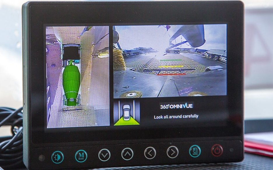 Zu sehen ist ein Monitor, der zum Kamerasystem eines Fahrmischers gehört. Er bietet Einzelansichten der verschiedenen Kameras am Fahrzeug und auch eine 360 Grad Rundumsicht vom gesamten Fahrzeug. Link zum Artikel.