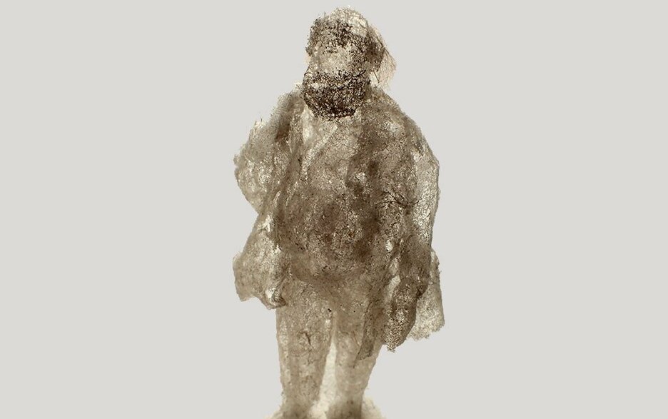 Das Bild zeigt eine aus Staubflusen gestaltete Figur des Künstlers Paul Hazelton. Die Staubkunst-Objekte wirken zerbrechlich und halten doch Jahrzehnte.  Link zum Artikel.