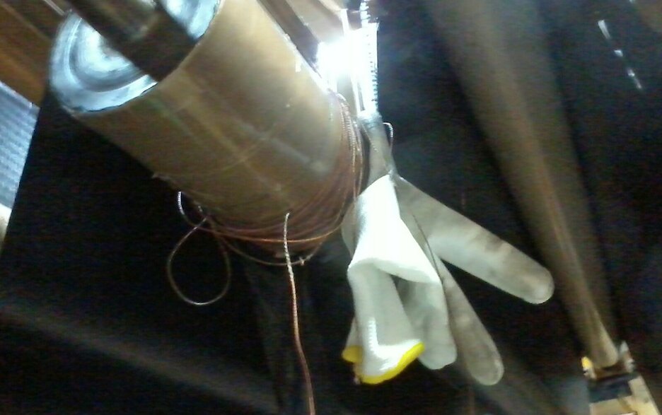 Das Bild zeigt einen eingezogenen Gummihandschuh an der Umlenkrolle einer Gummibahn. Hier hatte ein Mitarbeiter bei laufender Anlage versucht, Fasern zu entfernen. Link zum Artikel.