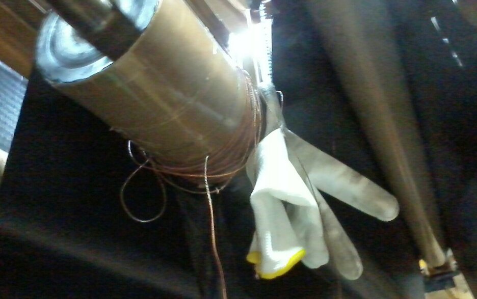 Das Bild zeigt einen eingezogenen Gummihandschuh an der Umlenkrolle einer Gummibahn. Hier hatte ein Mitarbeiter bei laufender Anlage versucht, Fasern zu entfernen. Link zur vergrößerten Darstellung des Bildes.
