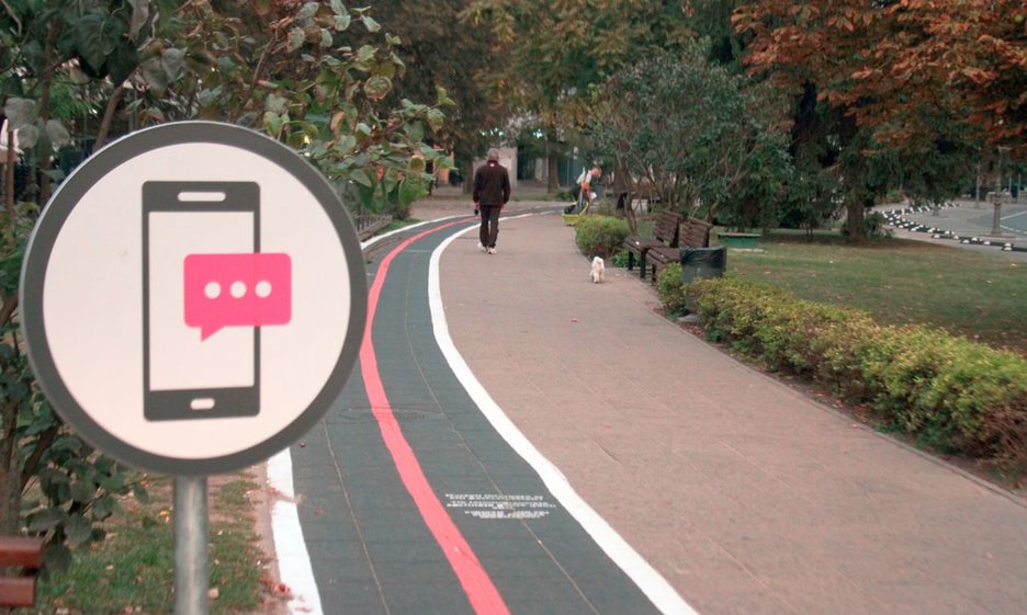 Zu sehen ist ein separater Gehweg für Handynutzer mit Beschilderung in der litauischen Hauptstadt Vilnius. Hier können Fußgänger beim Gehen entspannt mit dem Smartphone googlen, Nachrichten schreiben oder Musik hören. Link zur vergrößerten Darstellung des Bildes.
