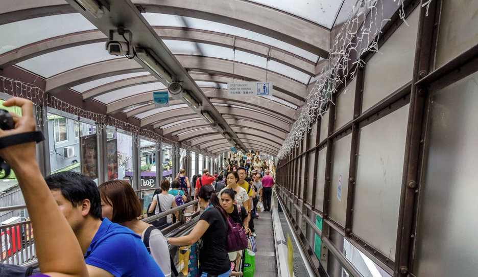 Das Bild zeigt Menschen auf der längsten Außenrolltreppe der Welt im Stadtteil Central von Hong Kong Island. Link zur vergrößerten Darstellung des Bildes.