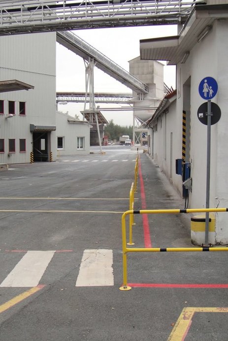 Das Bild zeigt ein Betriebsgelände mit getrennten Verkehrswegen durch Geländer und gut sichtbar markierte Bereiche auf dem Boden.