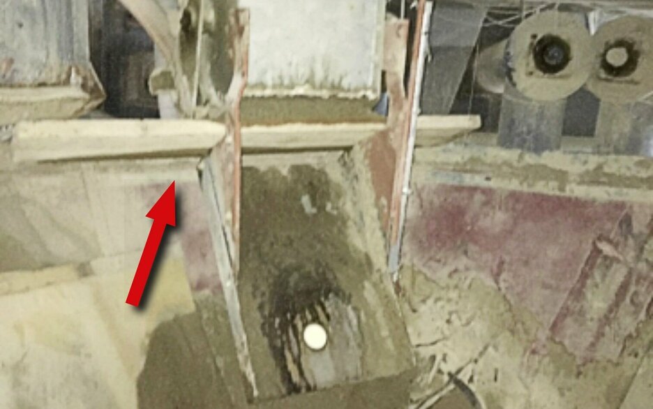 Das Bild zeigt den Blick in den Wiegebehälter eines Sandsilos. Hier ist ein Brett zu sehen, dass querliegend als Sicherung vor dem nachfließenden Sand dient. Link zum Artikel.