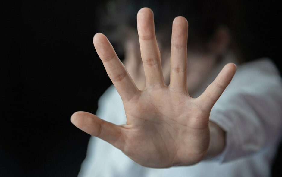 Das Foto ist ein Symbolbild für das Thema „Sexuelle Belästigung am Arbeitsplatz“ und was man dagegen tun kann. Zu sehen ist die Hand einer Frau, die sich mit abgespreizten Fingern abwehrend nach vorne bewegt. Der Hintergrund ist unscharf. Link zum Artikel.