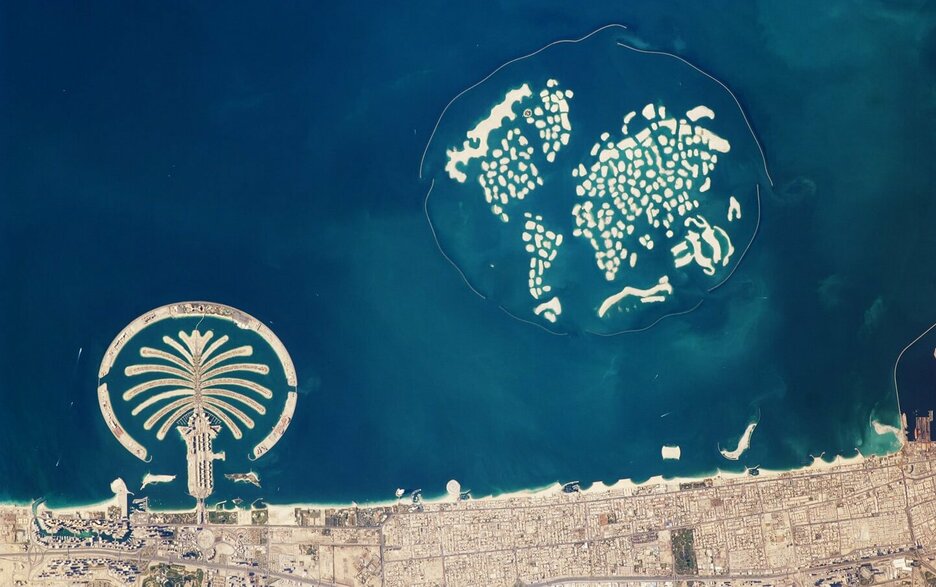 Das Bild ist von einem Satelliten aus dem All aufgenommen. Es zeigt künstlich aufgeschüttete Sandinseln im Persischen Golf, die eine besondere Form haben. Links auf dem Bild ist eine Palme zu sehen, die „The Palm Jumeirah“ genannt wird. Hier leben rund 10.000 Einwohner. Rechts sind 300 Inseln zu sehen, die so angeordnet wurden, dass sie die Kontinente der Welt abbilden. Diese künstliche Insellandschaft heißt „The World“ und ist bisher unbewohnt.  Link zum Artikel.