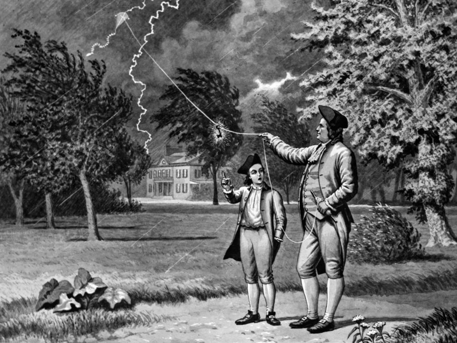Das Bild zeigt eine schwarz-weiß Zeichnung. Zu sehen ist der Erfinder des Blitzableiters Benjamin Franklin, der dazu ein Experiment mit einem selbstgebauten Drachen durchführte. Neben ihm steht ein Kind.