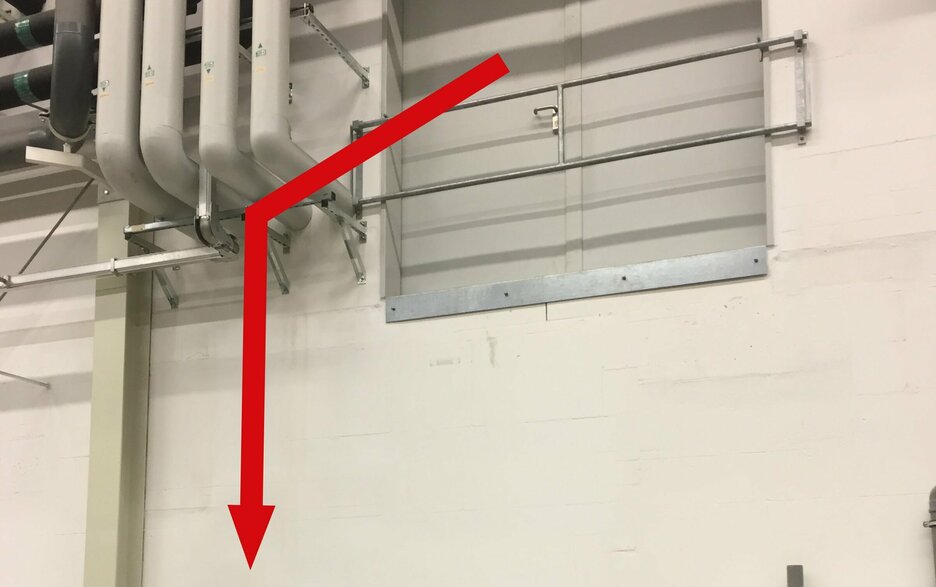 Das Bild zeigt eine geschlossene zweiflügelige Ladeluke von außen, die sich im Obergeschoss einer Werkshalle befindet. Durch diese stürzte ein Mitarbeiter bei Instandhaltungsarbeiten. Dies zeigt ein roter Pfeil, der nach unten weist. Link zum Artikel.