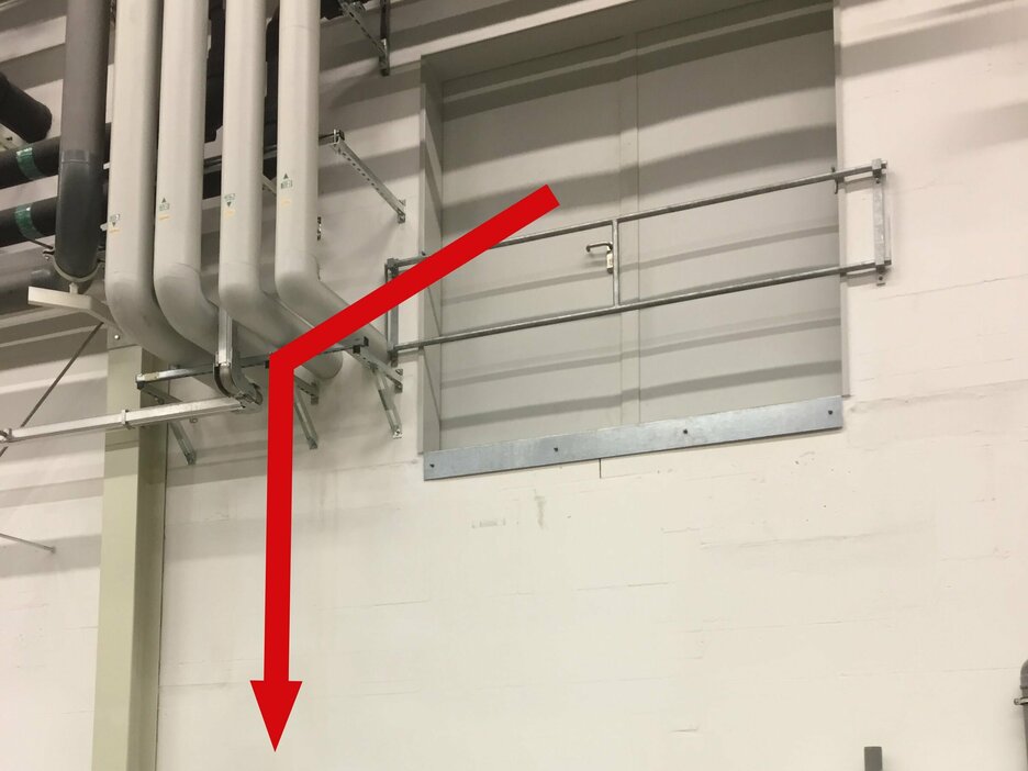 Das Bild zeigt eine geschlossene zweiflügelige Ladeluke von außen, die sich im Obergeschoss einer Werkshalle befindet. Durch diese stürzte ein Mitarbeiter bei Instandhaltungsarbeiten. Dies zeigt ein roter Pfeil, der nach unten weist. Link zur vergrößerten Darstellung des Bildes.