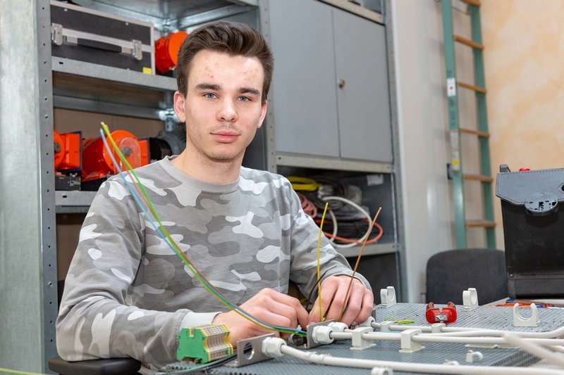Der Auszubildende zum Energieelektroniker Luca Naß übt in der Lehrwerkstatt den sicheren Aufbau und Umgang mit Schaltkreisen.