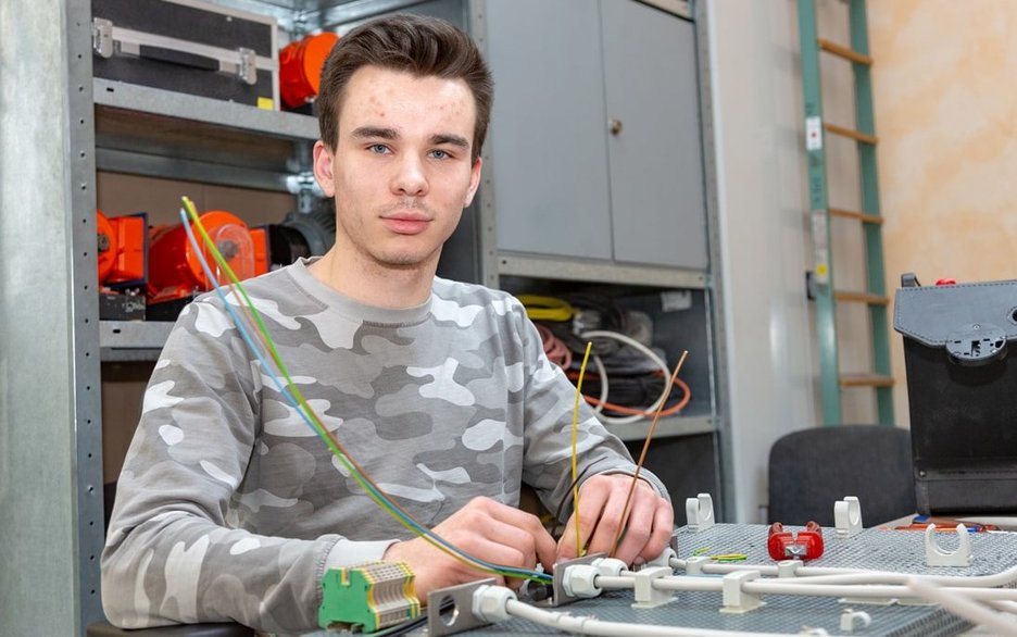 Der Auszubildende zum Energieelektroniker Luca Naß übt in der Lehrwerkstatt den sicheren Aufbau und Umgang mit Schaltkreisen. Link zum Artikel.