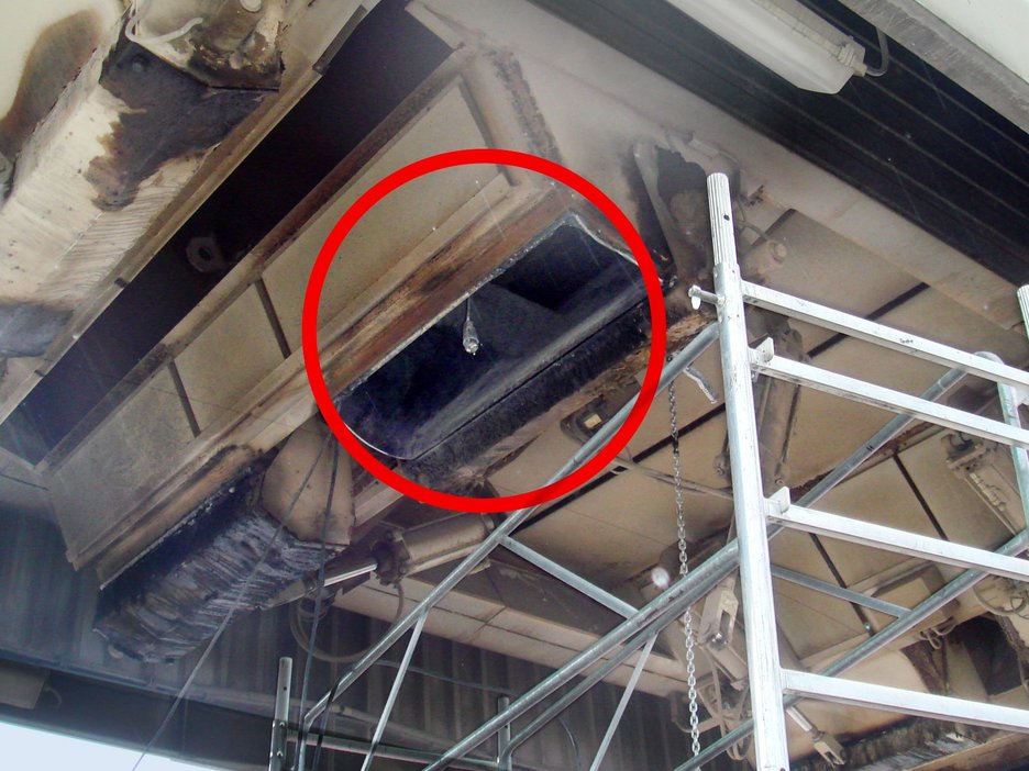 Das Foto zeigt ein Silo von außen unterhalb der Siloöffnung, in dem zwei Mitarbeiter beim Abstemmen und Reinigen durch eine riesige Asphaltscholle erschlagen wurden. Ein roter Kreis verweist auf die Öffnung.