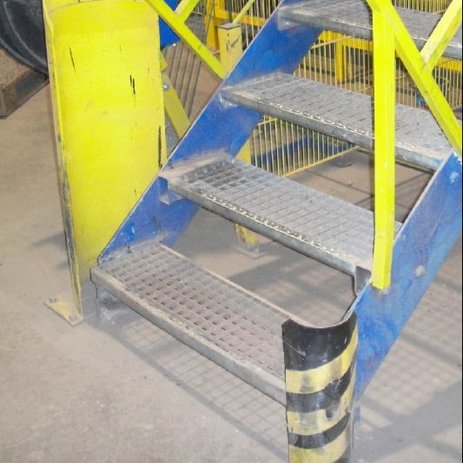 Das Bild zeigt einen Anfahrschutz am Treppenaufgang. Dieser schützt vor Beschädigungen durch Gabelstapler und sichert Fußgänger. Link zur vergrößerten Darstellung des Bildes.