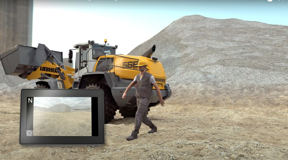Warnsystem hilft Zusammenstöße zwischen Erdbaumaschinen und Fußgängern zu vermeiden Die 3D-Grafik zeigt einen Radlader von hinten mit angehobener Schaufel, der im Gelände arbeitet. Ein Fußgänger, der von rechts kam, ist hinter der Erdbaumaschine entlanggelaufen und hat den Gefahrenbereich hinter sich gelassen. Das blaue Raster, das die Grenze symbolisiert, ist verschwunden. Der Fußgänger läuft sicher nach links aus dem Bild raus. Ein eingeklinkter Monitor links unten im Bild zeigt, was der Erdbaumaschinenführer gerade sieht. Der Fußgänger ist nicht mehr zu sehen. Der mögliche Zusammenstoß wurde vermieden. Link zur vergrößerten Darstellung des Bildes.