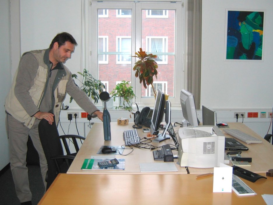 Das Bild zeigt einen Mitarbeiter, der eine Schallpegelmessung im Büro durchführt. Link zur vergrößerten Darstellung des Bildes.