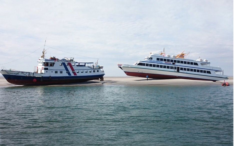 Das Bild zeigt zwei auf Grund gelaufene Ausflugsschiffe im nordfriesischen Wattenmeer. Dies war ein Erlebnis der besonderen Art für alle Fahrgäste, die gerettet werden mussten.