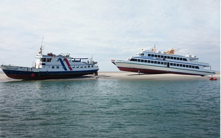Das Bild zeigt zwei auf Grund gelaufene Ausflugsschiffe im nordfriesischen Wattenmeer. Dies war ein Erlebnis der besonderen Art für alle Fahrgäste, die gerettet werden mussten. 