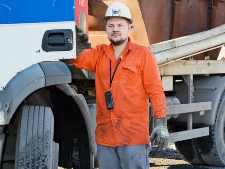 Das Bild zeigt den Absetzkipperfahrer Danny Klüver der Hanseatischen Recyclingprodukt-Vertriebsgesellschaft mbH an der geöffneten Tür eines Absetzkippers. Link zur vergrößerten Darstellung des Bildes.