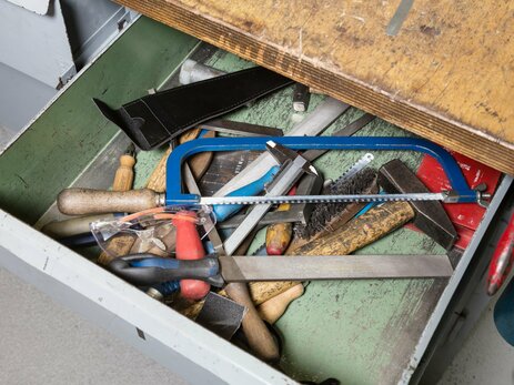 Das Bild zeigt scharfes, spitzes Werkzeug, das durcheinander in der Schublade einer Werkzeugbank liegt. Link zur vergrößerten Darstellung des Bildes.