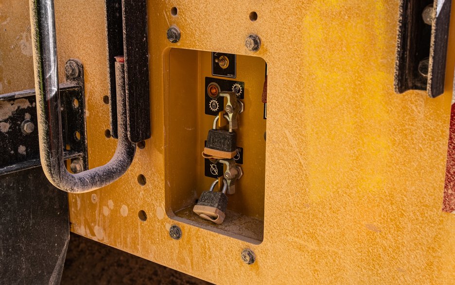 Das Foto zeigt das Lockout-Tagout-System an einer Erdbaumaschine. Es ermöglicht sichere Wartungsarbeiten, weil hier der Gefahrenbereich mit persönlichen Vorhängeschlössern gesichert ist.