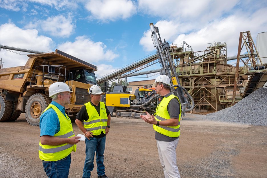 Das Bild zeigt ein Gespräch zu dritt auf dem Werksgelände der Firma Westkalk. Zu sehen sind links der Betriebsarzt Winfried Theisgen, in der Mitte der Sicherheitsingenieur der Berufsgenossenschaft Rohstoffe und chemische Industrie Carsten Moll und rechts der Technische Leiter der Firma Westkalk, Dr. Guido Mausbach. Link zur vergrößerten Darstellung des Bildes.