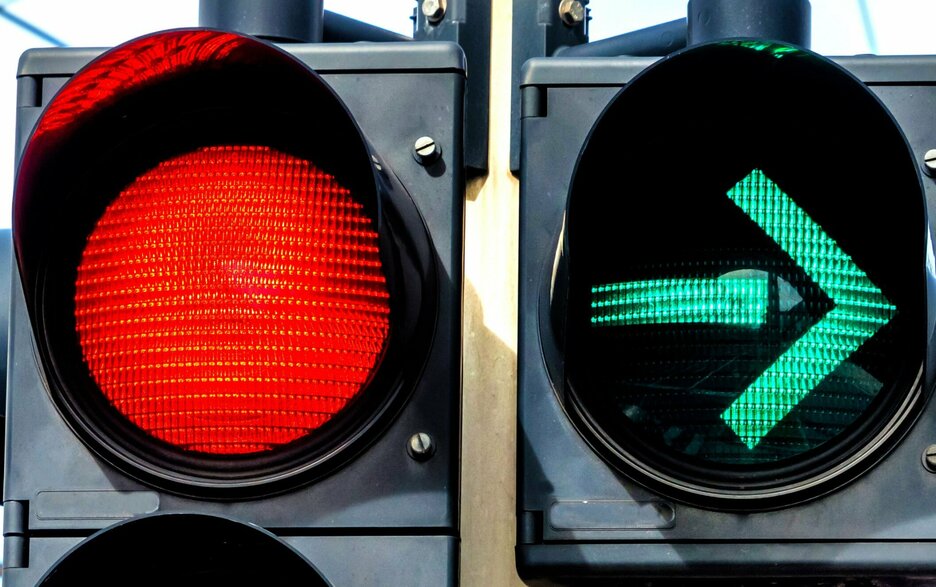 Das Foto zeigt den Ausschnitt einer Ampel. Auf der linken Seite das rote Licht der Ampel zu sehen. Rechts daneben ist eine nach rechts zeigende grüne Pfeilampel. Es symbolisiert, was wichtig ist in Bezug auf das Thema „Risikokompetenz“. Hier geht es auch um das rechtzeitige innerliche Anhalten in riskanten Situationen und das sichere Abbiegen in die richtige Richtung mit dem eigenen Verhalten. Link zum Artikel.