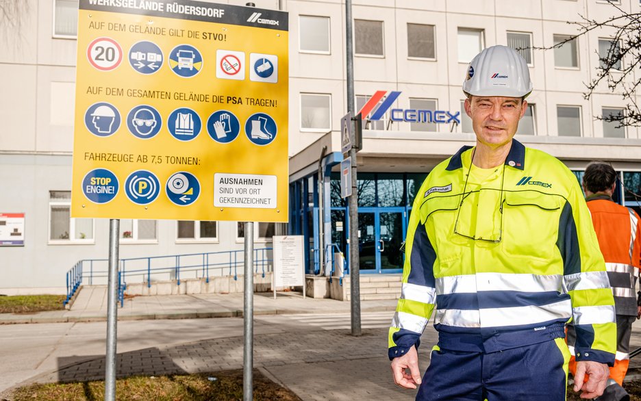 Das Bild zeigt den Betriebsratsvorsitzenden Roland Falkenhan in Warnschutzkleidung auf dem Werksgelände von Cemex Rüdersdorf. Link zum Artikel.