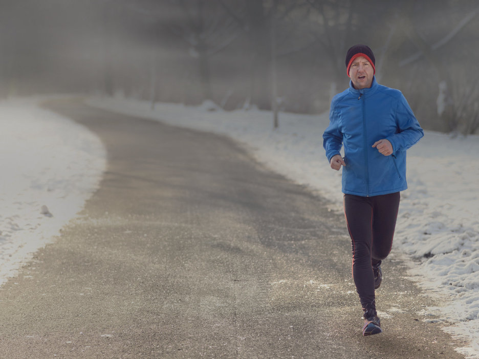 Zu sehen ist ein joggender Mann im Winter, hinter dem schwarze Wolken eine düstere Stimmung verbreiten. Dies steht als Symbol für das Thema „Winterdepressionen“. Link zur vergrößerten Darstellung des Bildes.