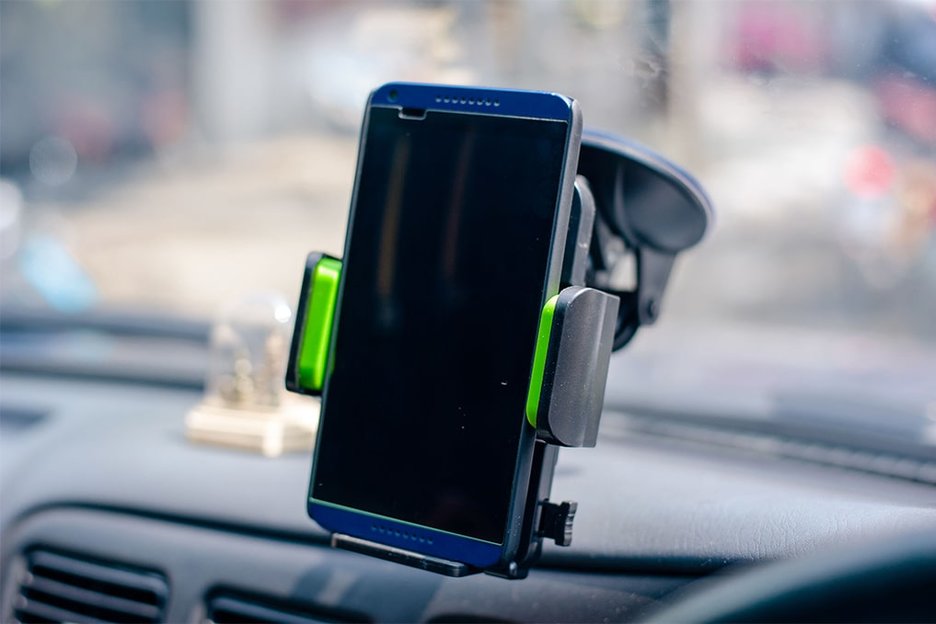 Zu sehen ist ein Smartphone, das im Auto fest in einer Halterung sitzt. Link zur vergrößerten Darstellung des Bildes.