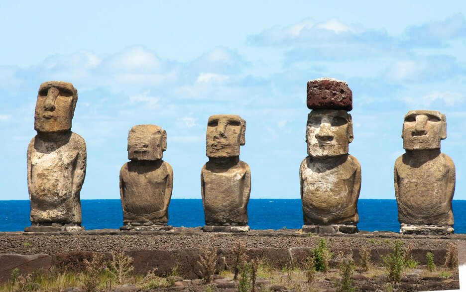 Das Bild zeigt, die zum UNESCO-Weltkulturerbe gehörenden Moai-Steinfiguren der Osterinsel. Sie bestehen aus weichem Tuffgestein, das langsam zerbröselt. Sie zu retten, ist ein Wettlauf gegen die Zeit. Die Statuen haben im Vergleich zum kleinen, rundlichen Körper überproportionale eckige Köpfe. Link zum Artikel.