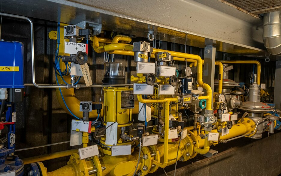 Das Bild zeigt eine beschriftete Anlage mit mehreren gelben Rohrleitungen im Werk Schladen der Nordzucker AG. Die Informationen und Kennzeichnungen helfen Bedienern und Instandhaltern, Teile richtig zuzuordnen und Gefahren an Anlagen zu vermeiden.