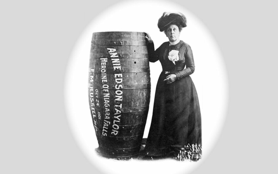 Das Schwarz-Weiß-Foto zeigt die 63-jährige US-Amerikanerin Annie Edson Taylor frontal im Portrait neben einem 1,40 m hohen Holzfass, in dem sie sich als erster Mensch die Niagarafälle hinabstürzte. Das Fass trägt ihren Namen sowie auf Englisch den Schriftzug „Heldin der Niagarafälle“, das Datum ihres Stunts, den 24. Oktober 1901 und den Hersteller des Fasses. Link zum Artikel.