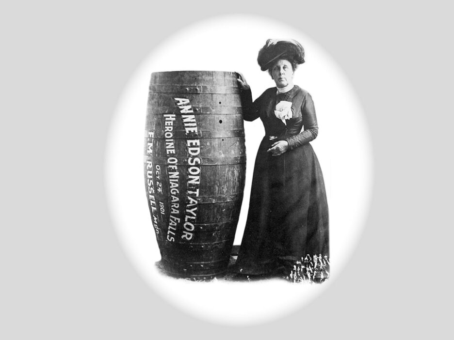 Das Schwarz-Weiß-Foto zeigt die 63-jährige US-Amerikanerin Annie Edson Taylor frontal im Portrait neben einem 1,40 m hohen Holzfass, in dem sie sich als erster Mensch die Niagarafälle hinabstürzte. Das Fass trägt ihren Namen sowie auf Englisch den Schriftzug „Heldin der Niagarafälle“, das Datum ihres Stunts, den 24. Oktober 1901 und den Hersteller des Fasses. Link zur vergrößerten Darstellung des Bildes.