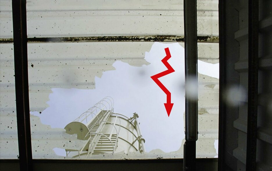 Das Bild zeigt ein durchgebrochenes Lichtelement im Dach von unten. Durch das Loch sieht man das Silo, zu dem ein Mitarbeiter zwecks Inspektion gehen wollte. Ein roter, gezackter Pfeil verdeutlicht den Durchbruch.