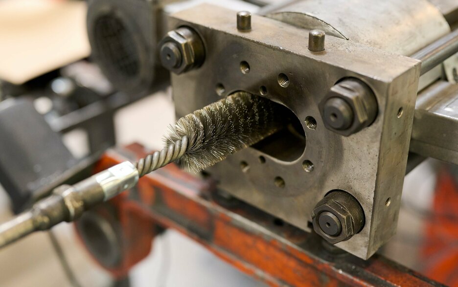 Zu sehen ist das Detail der Reinigungsbürste, die sich am Kopf der Tunnelreinigungsmaschine befindet. Die Bürste wird gerade in eine Öffnung eingeführt. Zum Reinigen wird sie vor- und zurückbewegt.