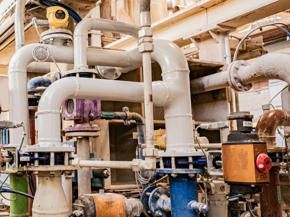 Das Foto zeigt den Ausschnitt einer Anlage im Werk Schladen. Neben großen Pumpen gibt es zig Kilometer Rohrleitungen, in denen heiße Flüssigkeiten und Gase transportiert werden. 