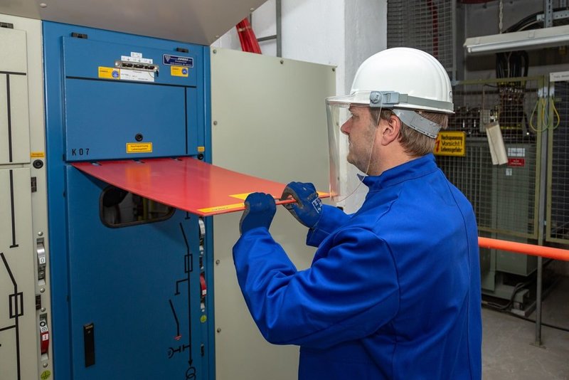 Elektrotechniker und Sicherheitsfachkraft Andreas Nienhaus nutzt zur Entriegelung der Tür zum Schaltschrank ein rotes Steckblech.